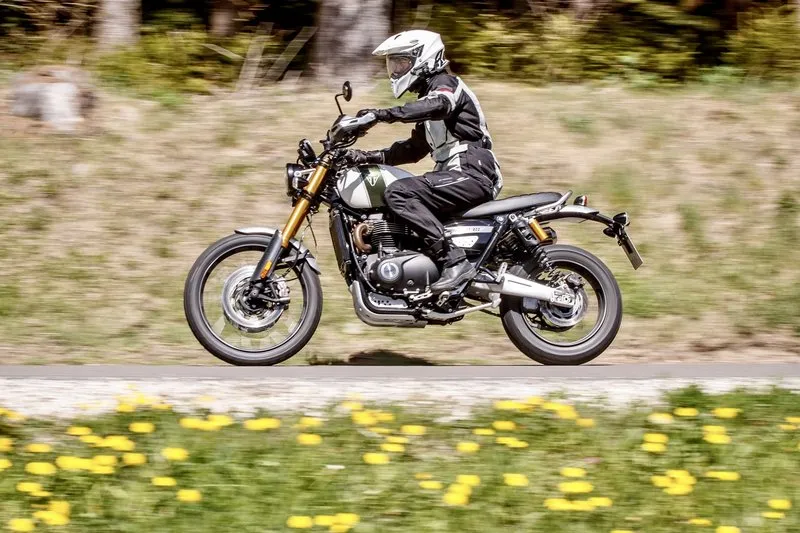 Nils on a Triumph Scrambler XE on a rural road — the kind of premium-built scrambler with the suspension hardware to back up its appearance.