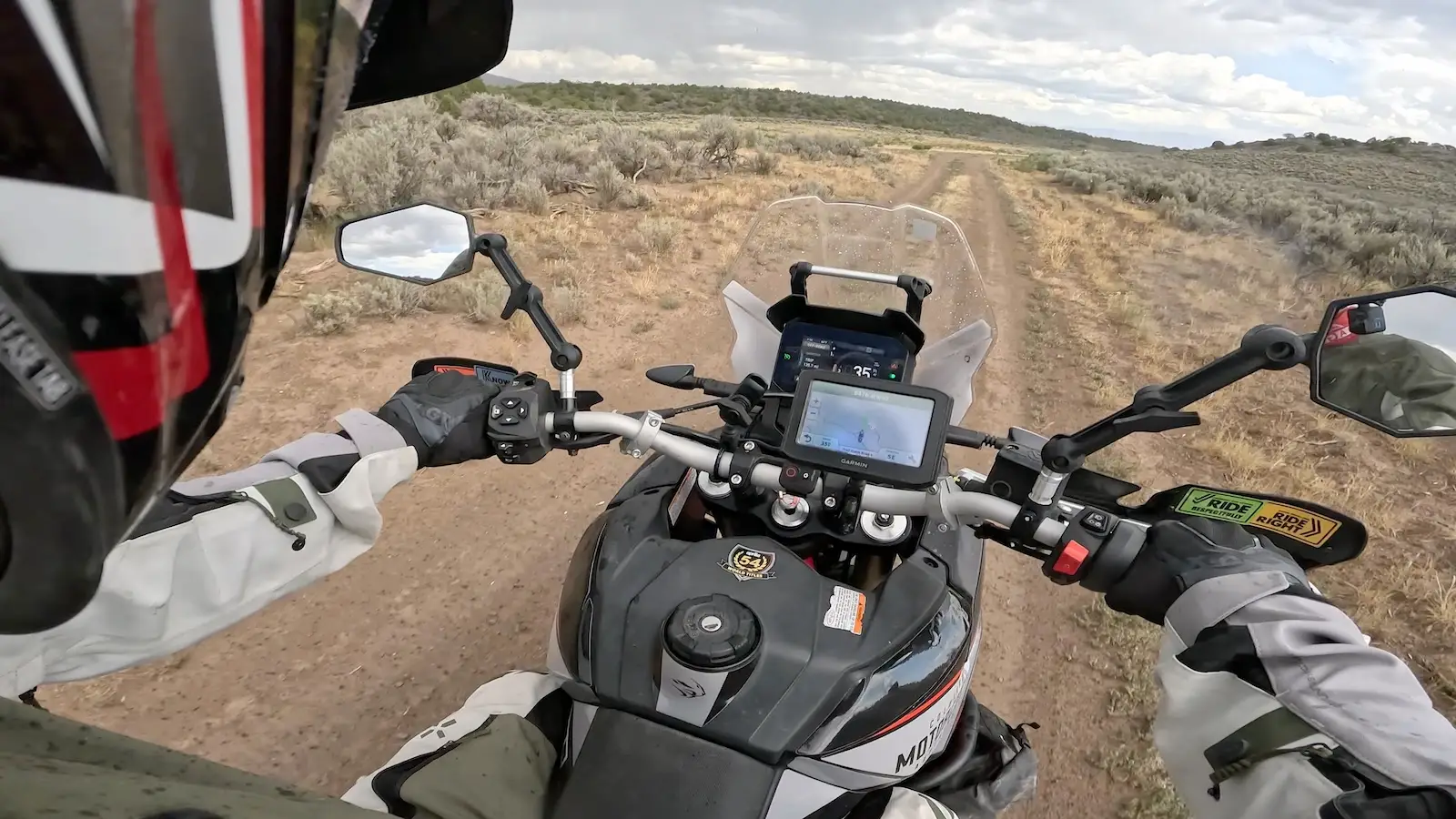 POV from the Aprilia Tuareg 660 bars on a sandy two-track through high-desert sagebrush in Colorado