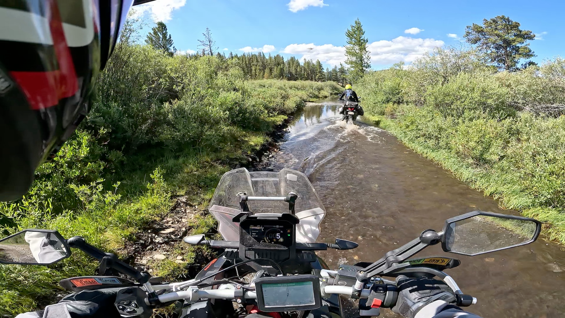 Cockpit view from the Aprilia Tuareg 660 at a Colorado water crossing with the second rider ahead