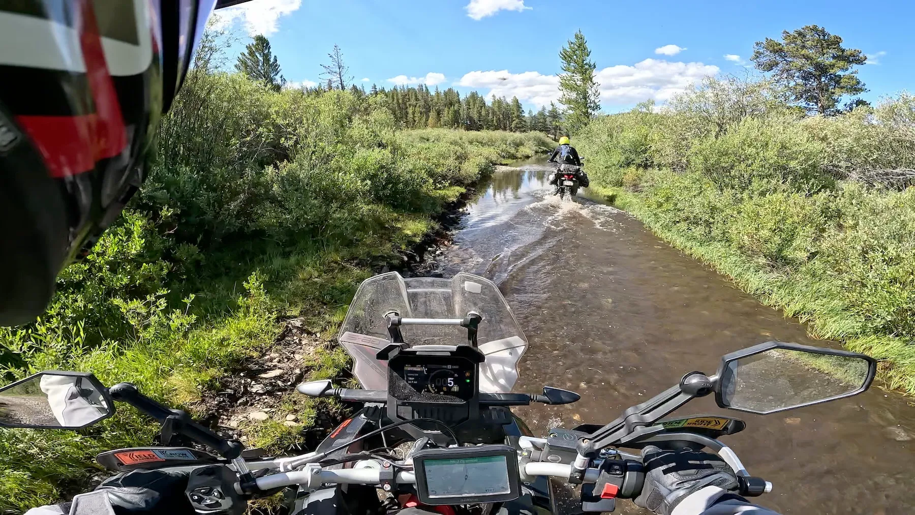 Cockpit view from the Aprilia Tuareg 660 at a Colorado water crossing with the second rider ahead