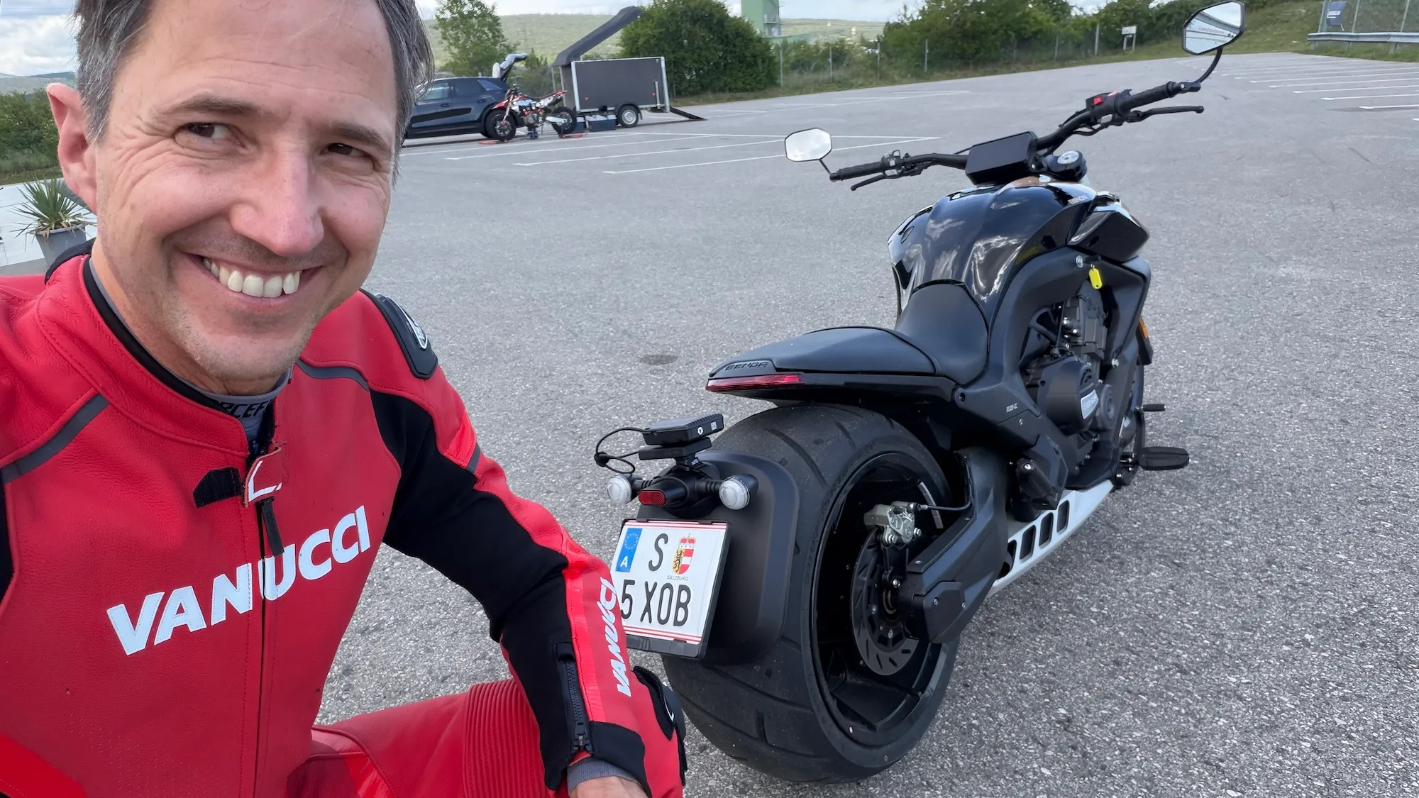 NastyNils selfie with the Benda LFC 700 PRO MY2026, all-black muscle cruiser with massive rear tire, at Motorsport Arena Austria.