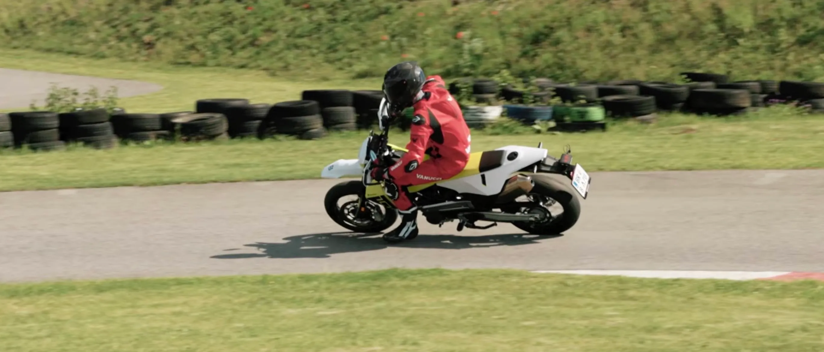 Husqvarna 701 Supermoto MY2026 seen side-on through a fast section of the Bad Fischau supermoto track, rider tucked in behind the number board.