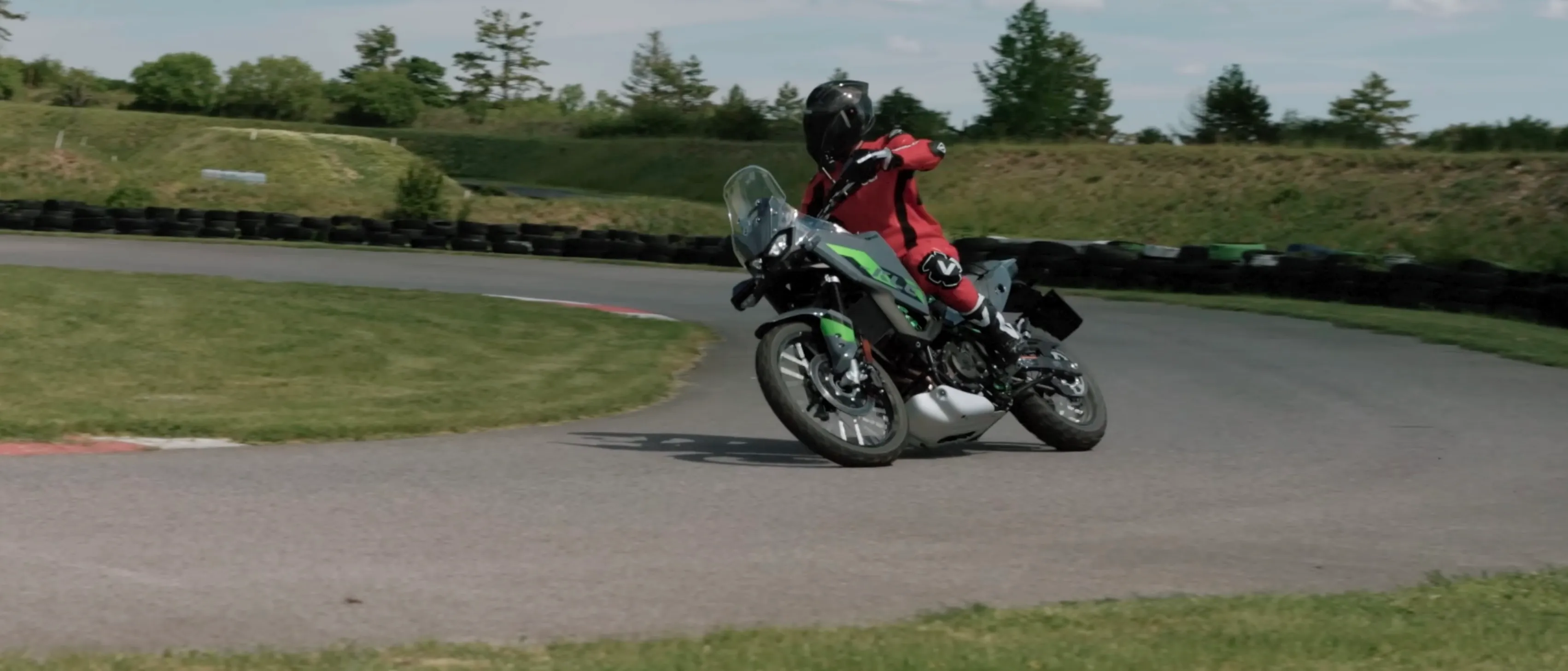Kawasaki KLE500 SE turning in at Bad Fischau, seen head-on with the screen, spoked front wheel and the rider hung off to the inside.