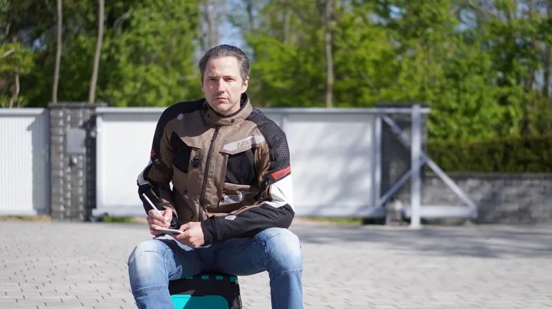 Nils Mueller in adventure-touring gear at the Austrian supermoto-track facility on test day, full enduro-touring kit, no helmet, before the timed laps.