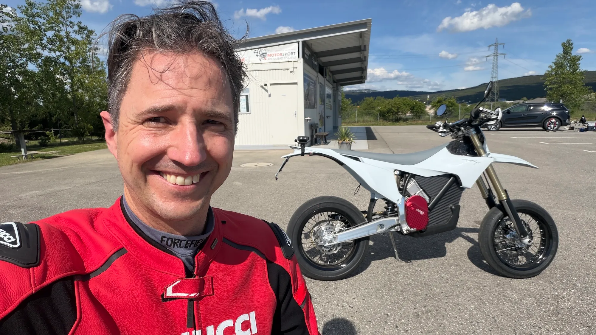 NastyNils selfie with the Stark Varg SM MY2026 electric supermoto — white frame, red motor unit, minimalist design at Motorsport Arena Austria.